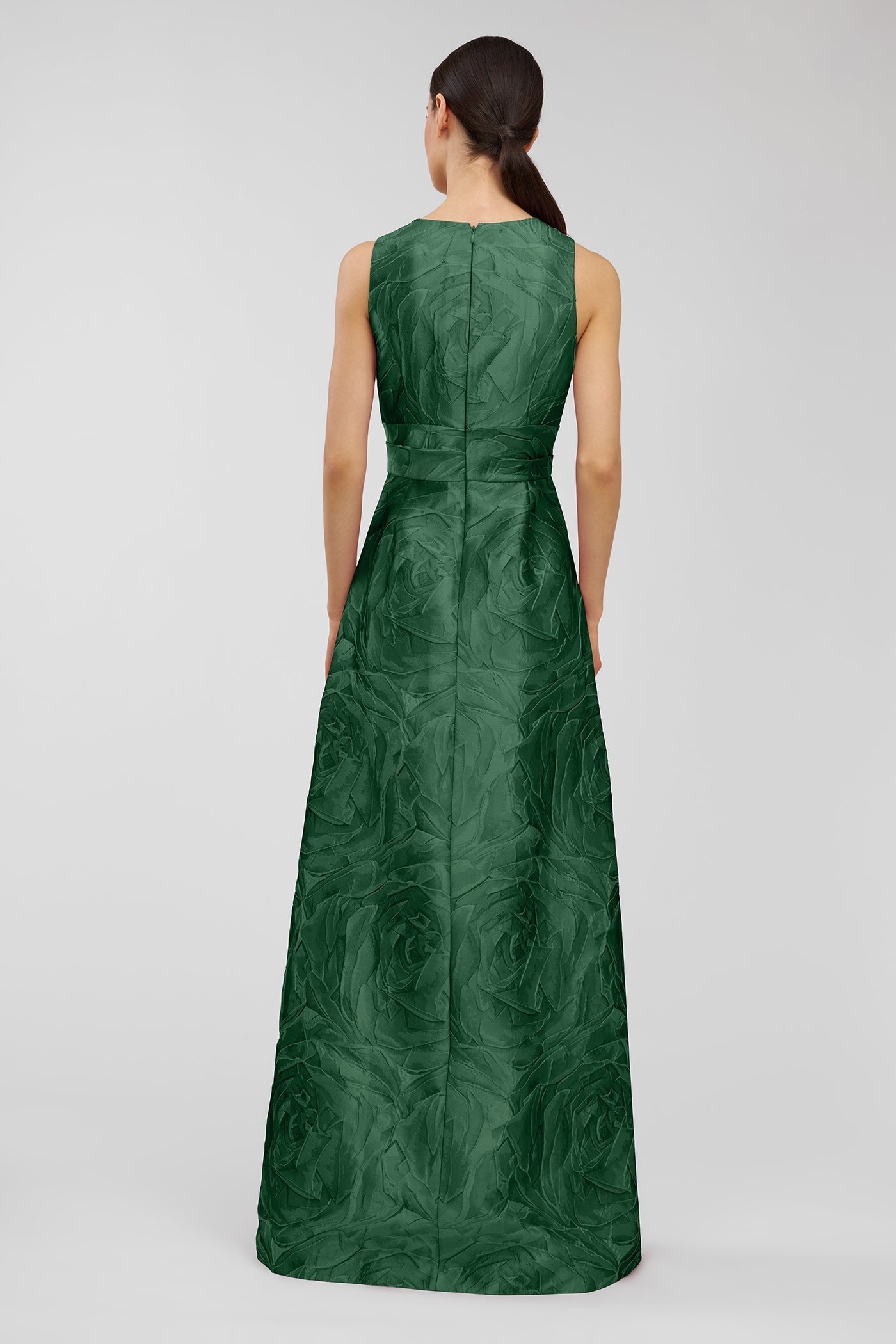 Green patterned dress worn by a model on a light gray background