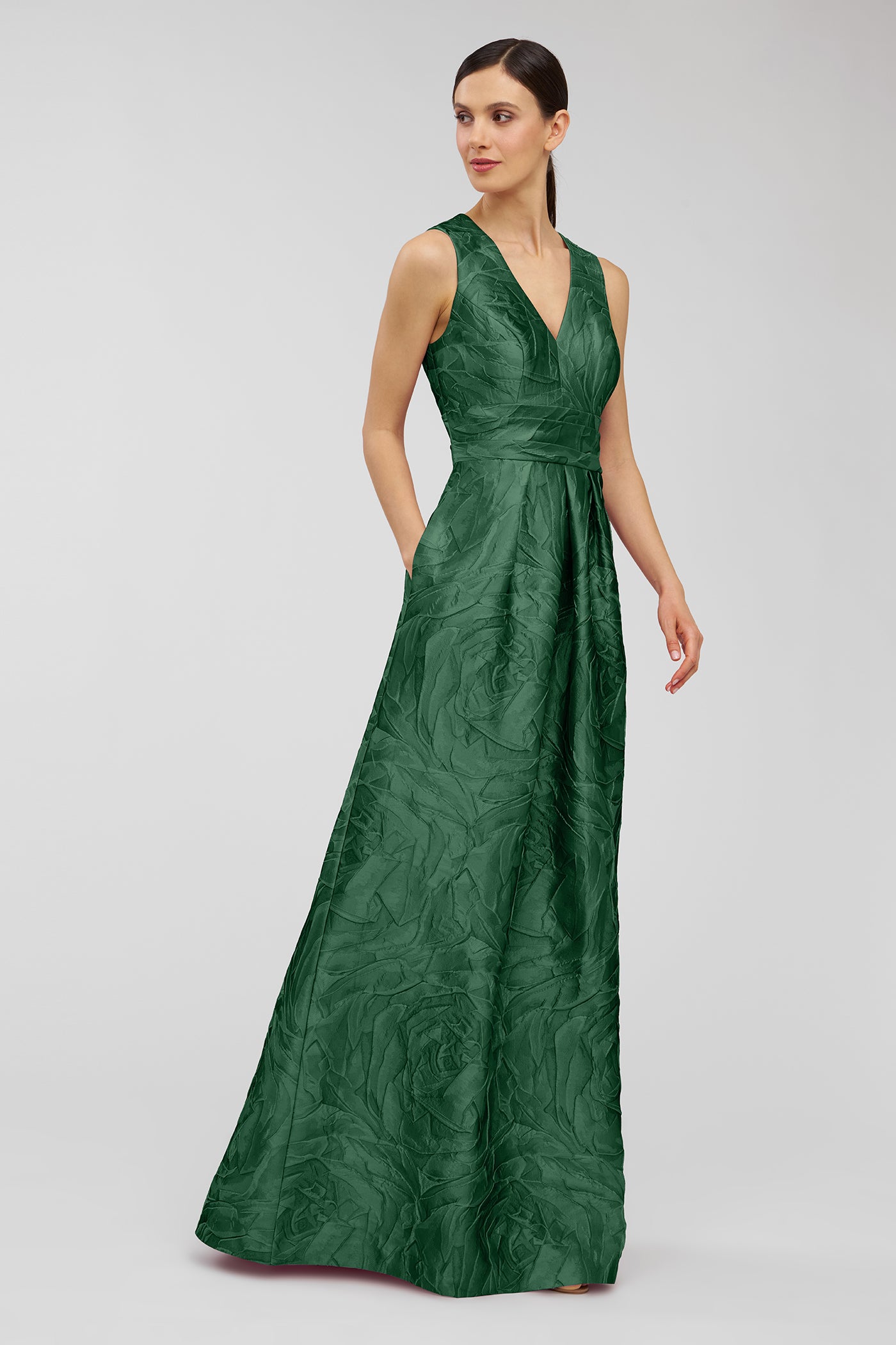 Woman wearing a green evening gown on a gray background