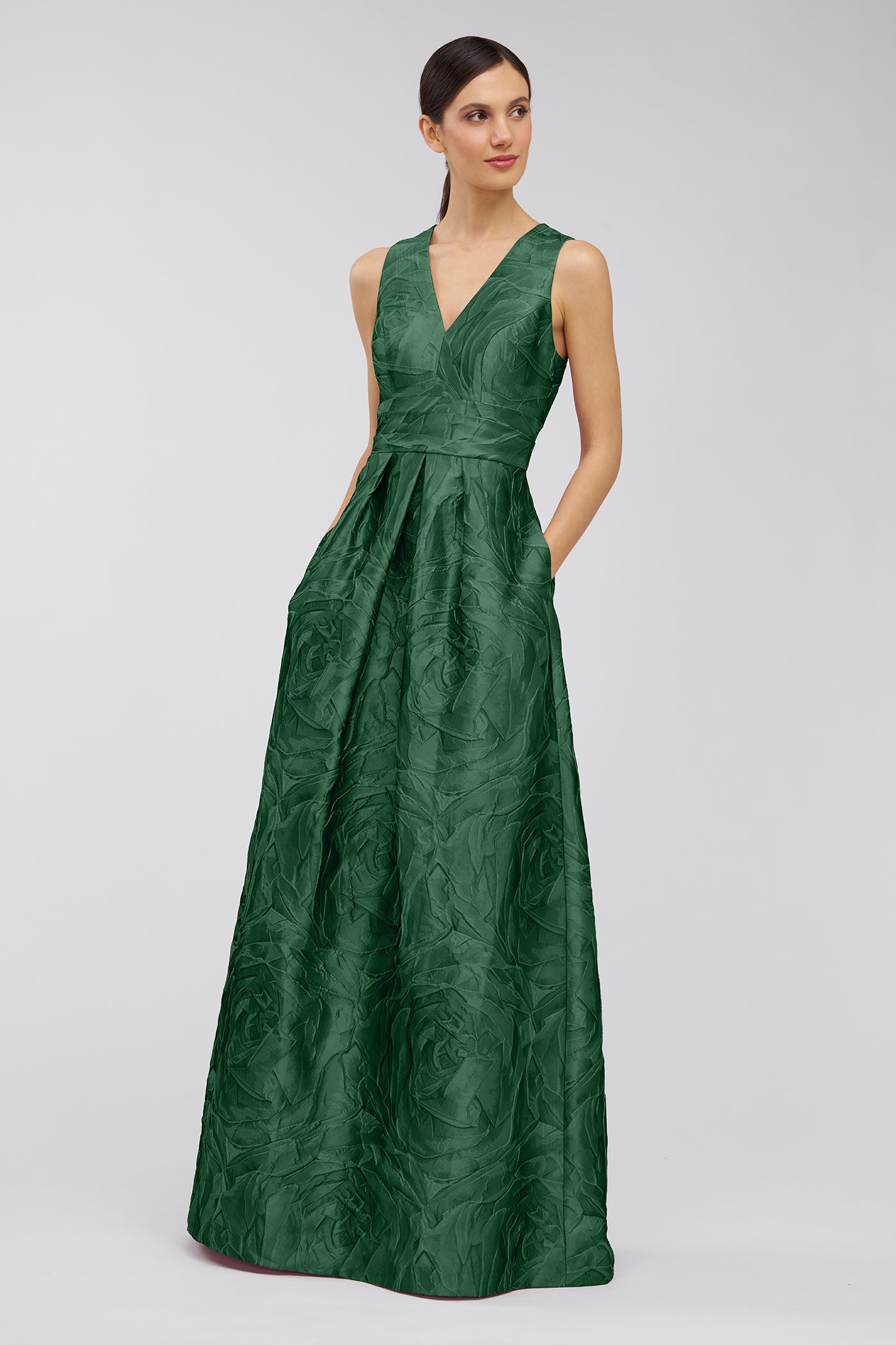 Woman wearing a green patterned dress on a light gray background