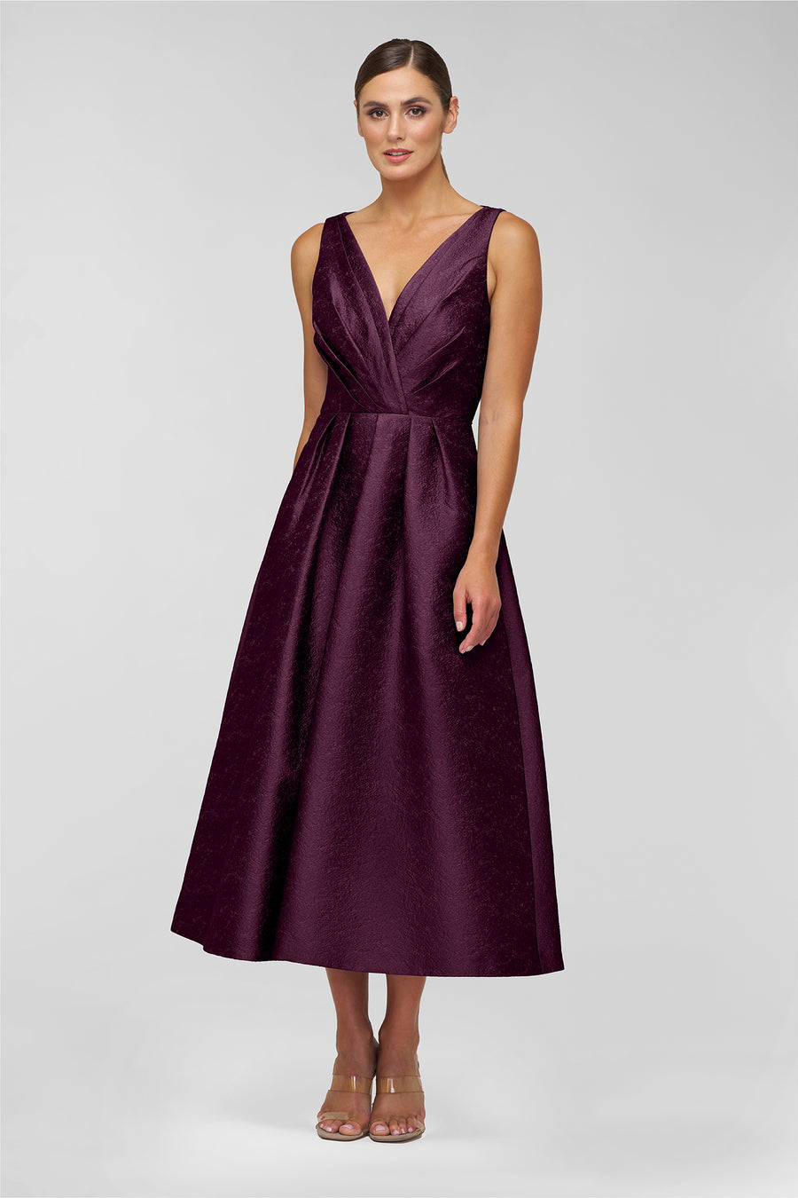 Woman wearing a purple dress on a light gray background