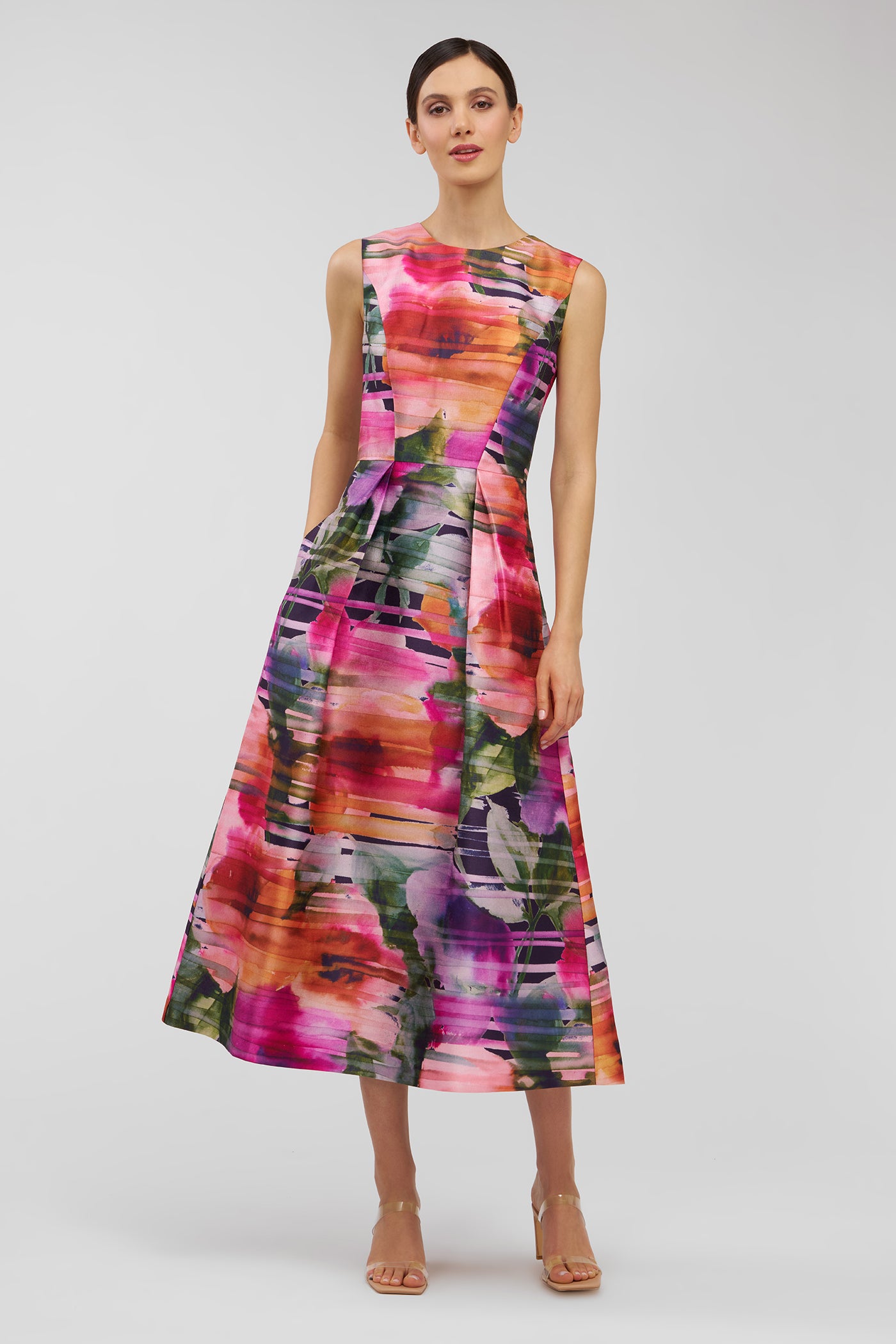 Woman wearing a colorful abstract patterned dress on a light gray background