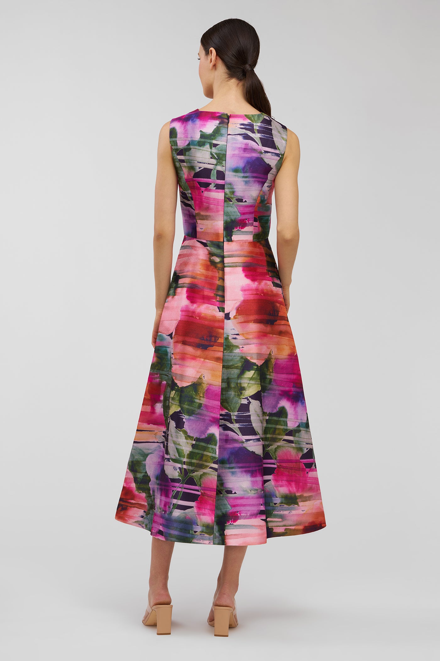 Woman wearing a colorful floral dress on a white background