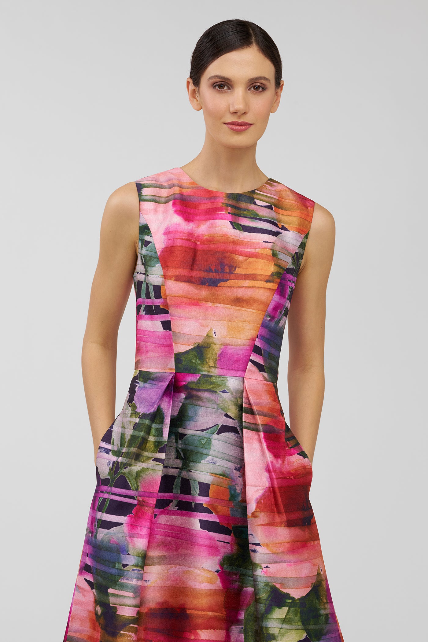 Model wearing a colorful sleeveless dress with a abstract pattern on a plain background