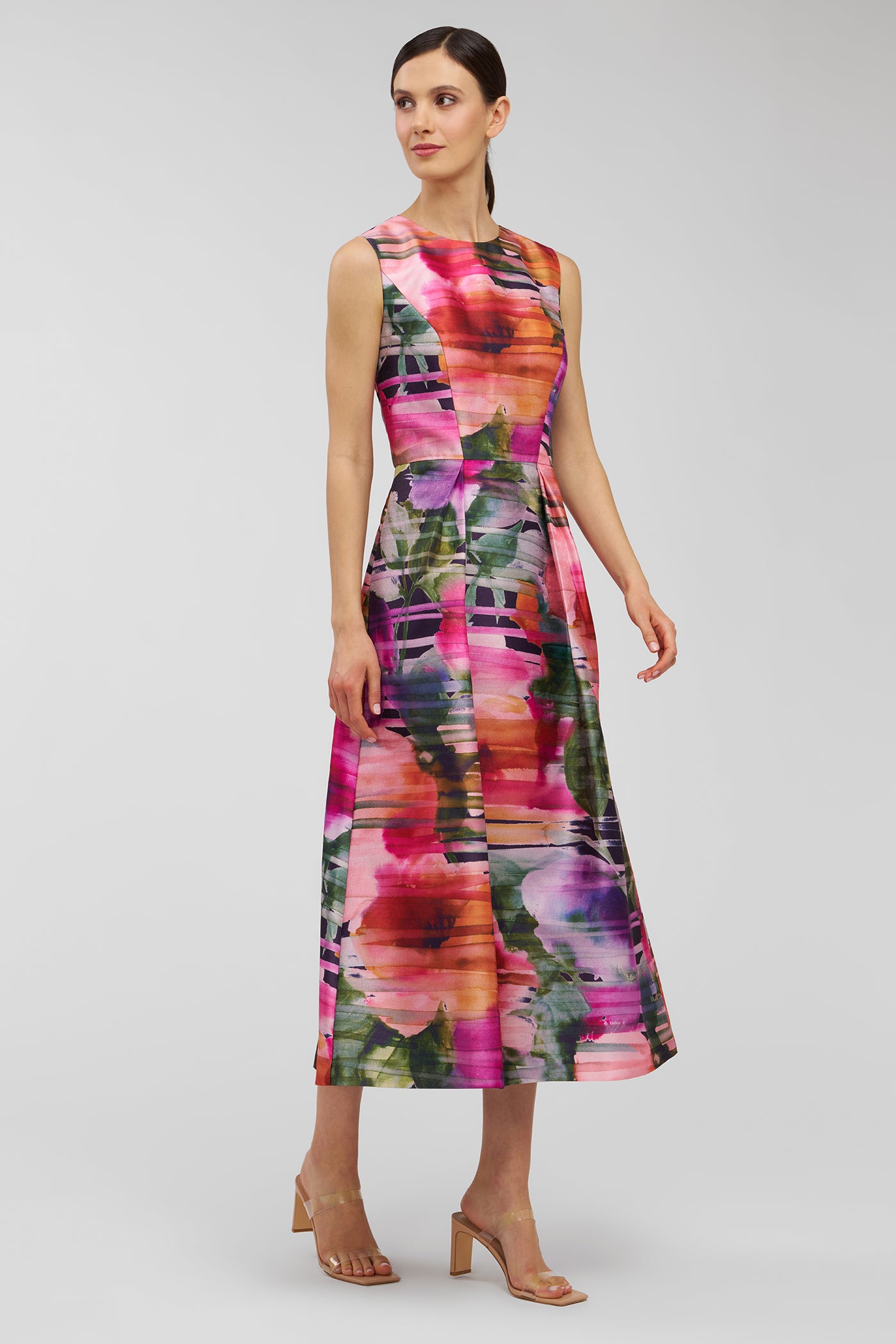 Woman wearing a colorful floral dress on a light gray background