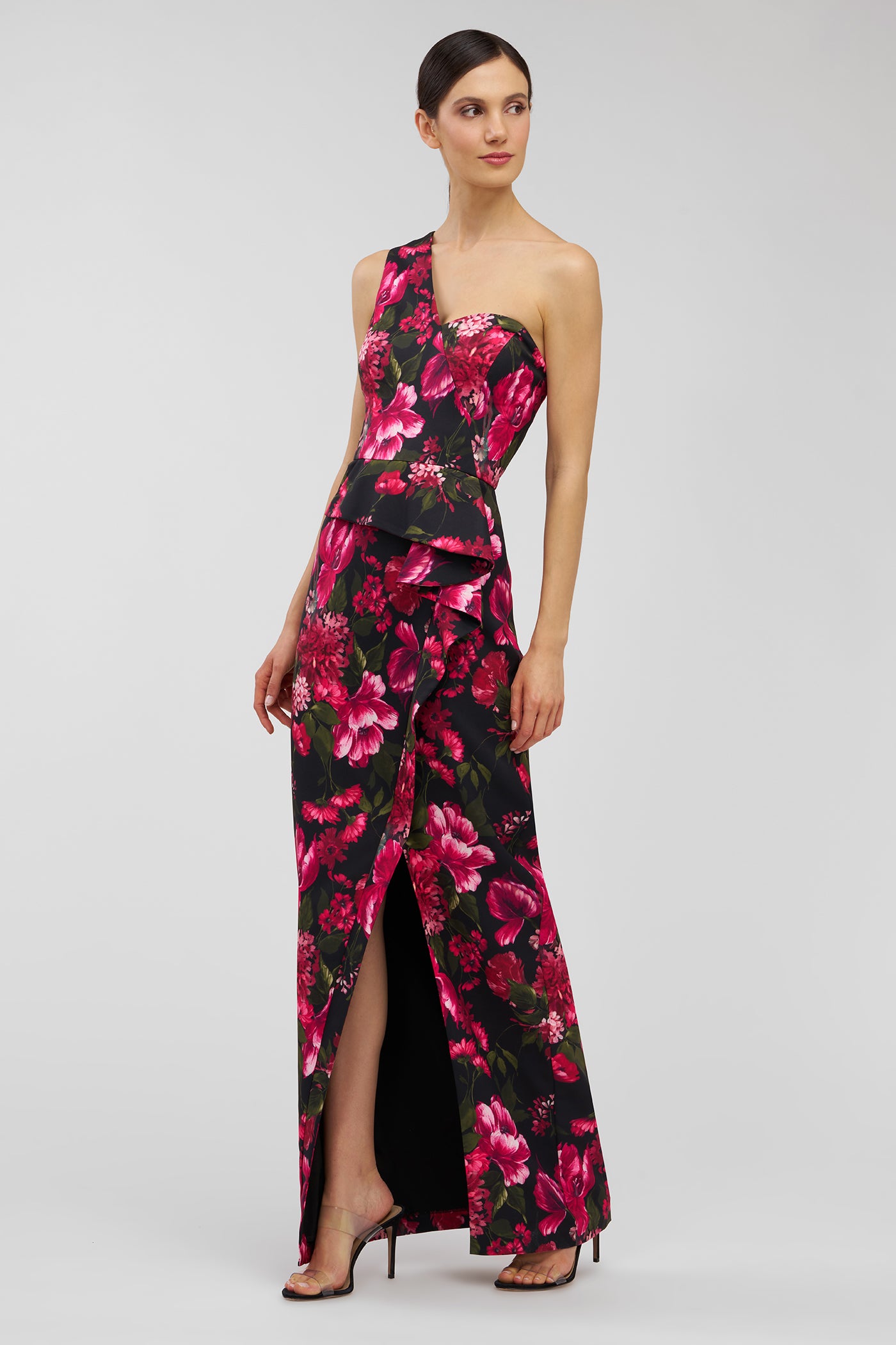 Woman wearing a floral one-shoulder gown on a white background