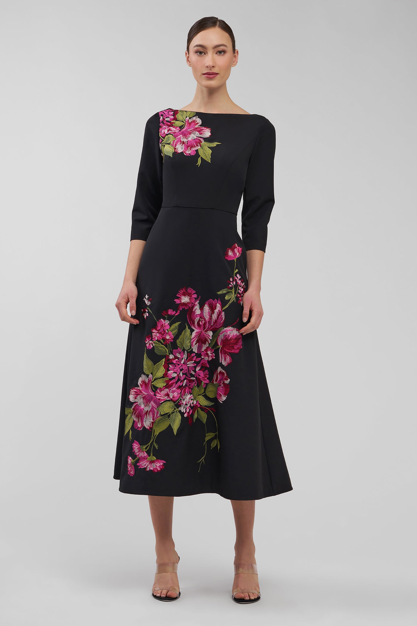 Black dress with floral embroidery on a plain background