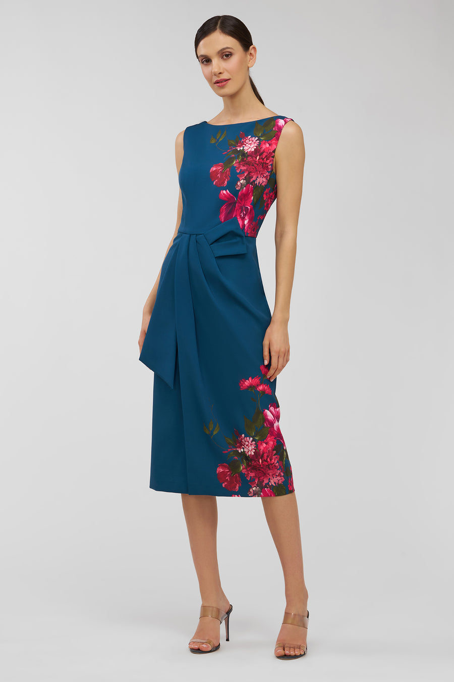 Woman wearing a blue dress with pink floral patterns on a white background