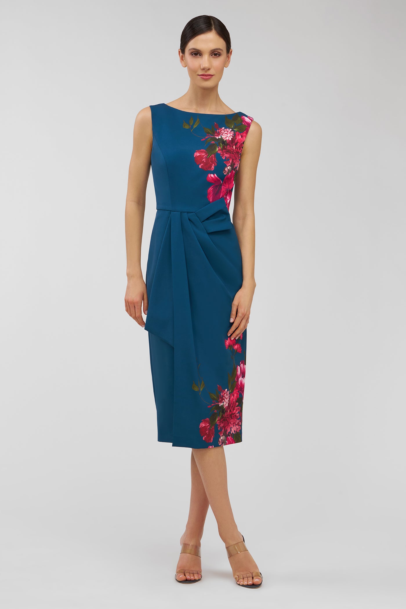 Woman wearing a blue dress with floral patterns on a light gray background