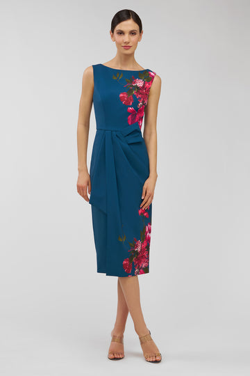 Woman wearing a blue dress with floral patterns on a light gray background