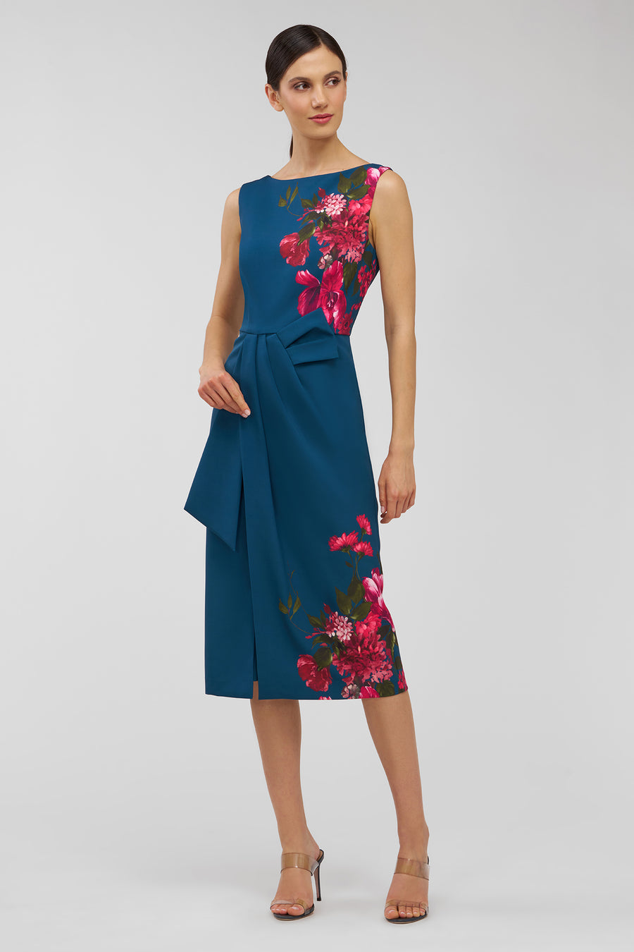 Woman wearing a blue dress with floral patterns on a white background
