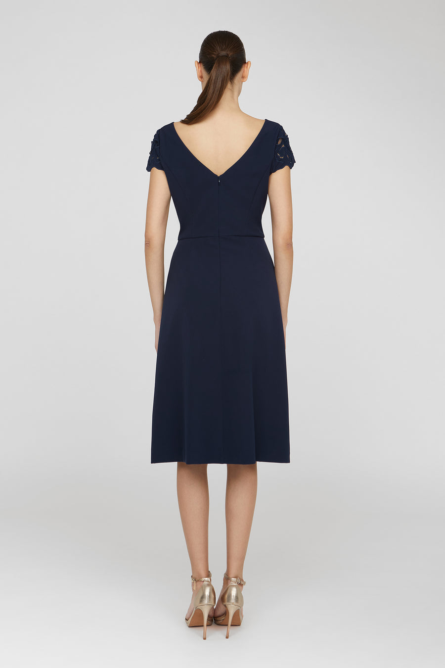 Navy blue dress worn by a model on a white background