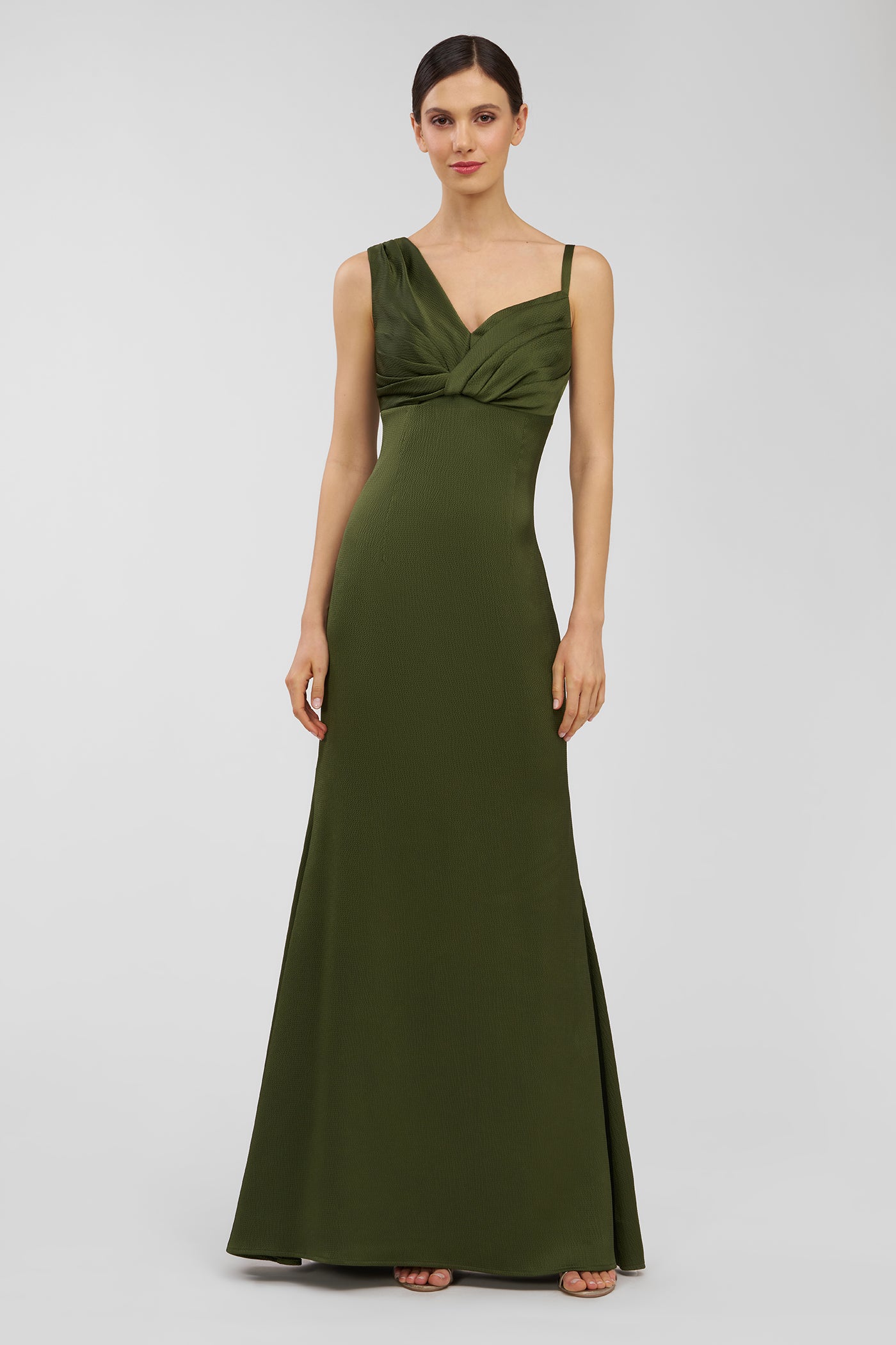 Woman wearing a green evening gown on a light gray background