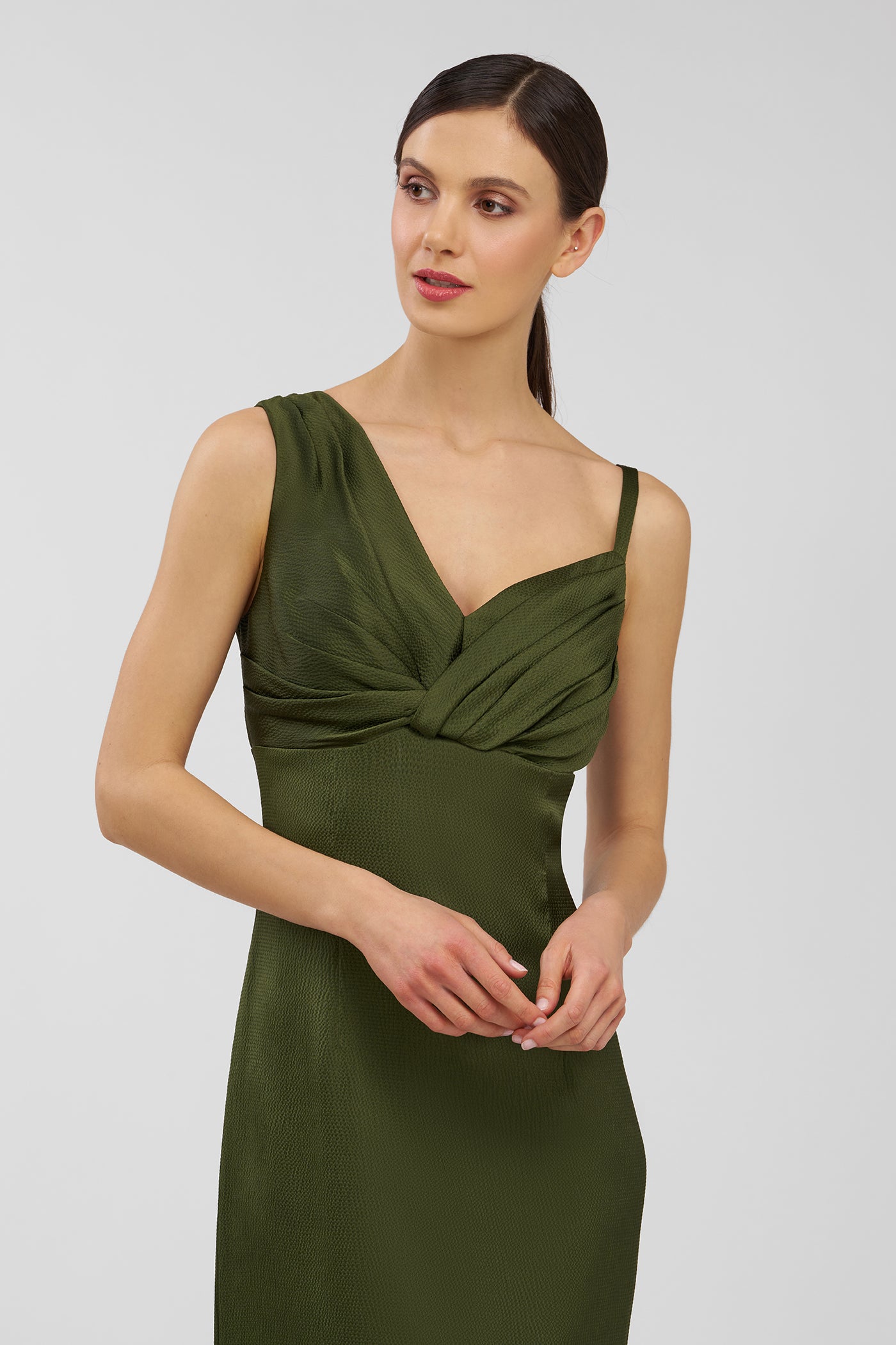 Woman wearing a green dress against a plain background