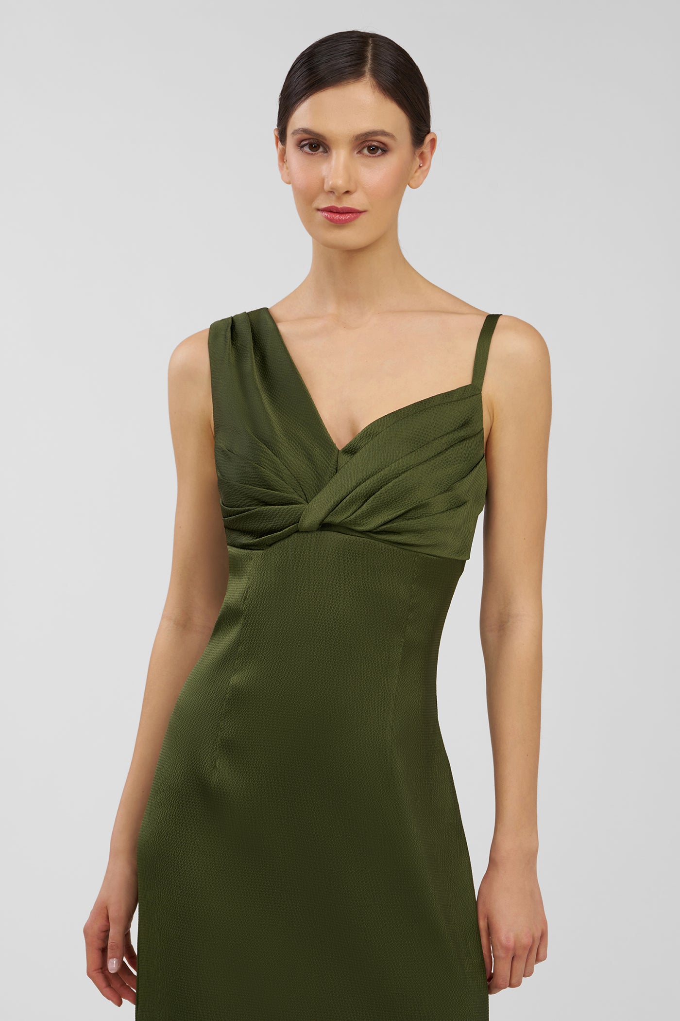Woman wearing a green dress against a plain background