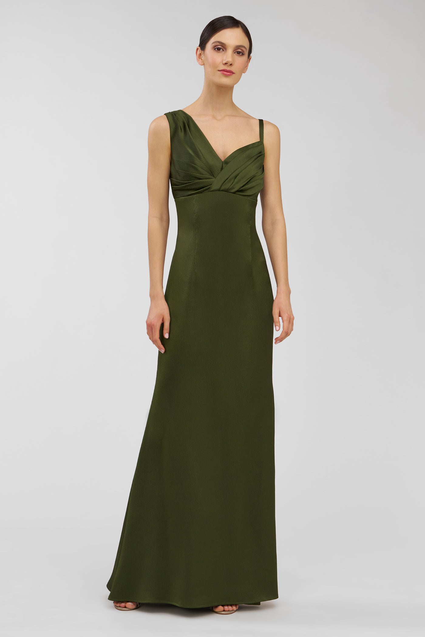 Woman wearing a green evening gown against a white background