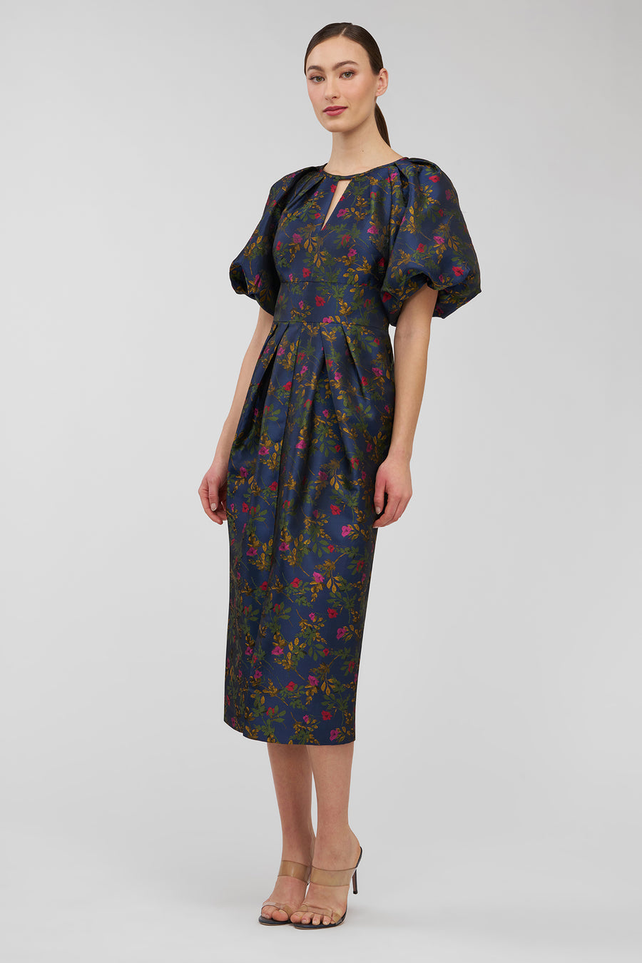 Woman wearing a dark floral dress on a white background