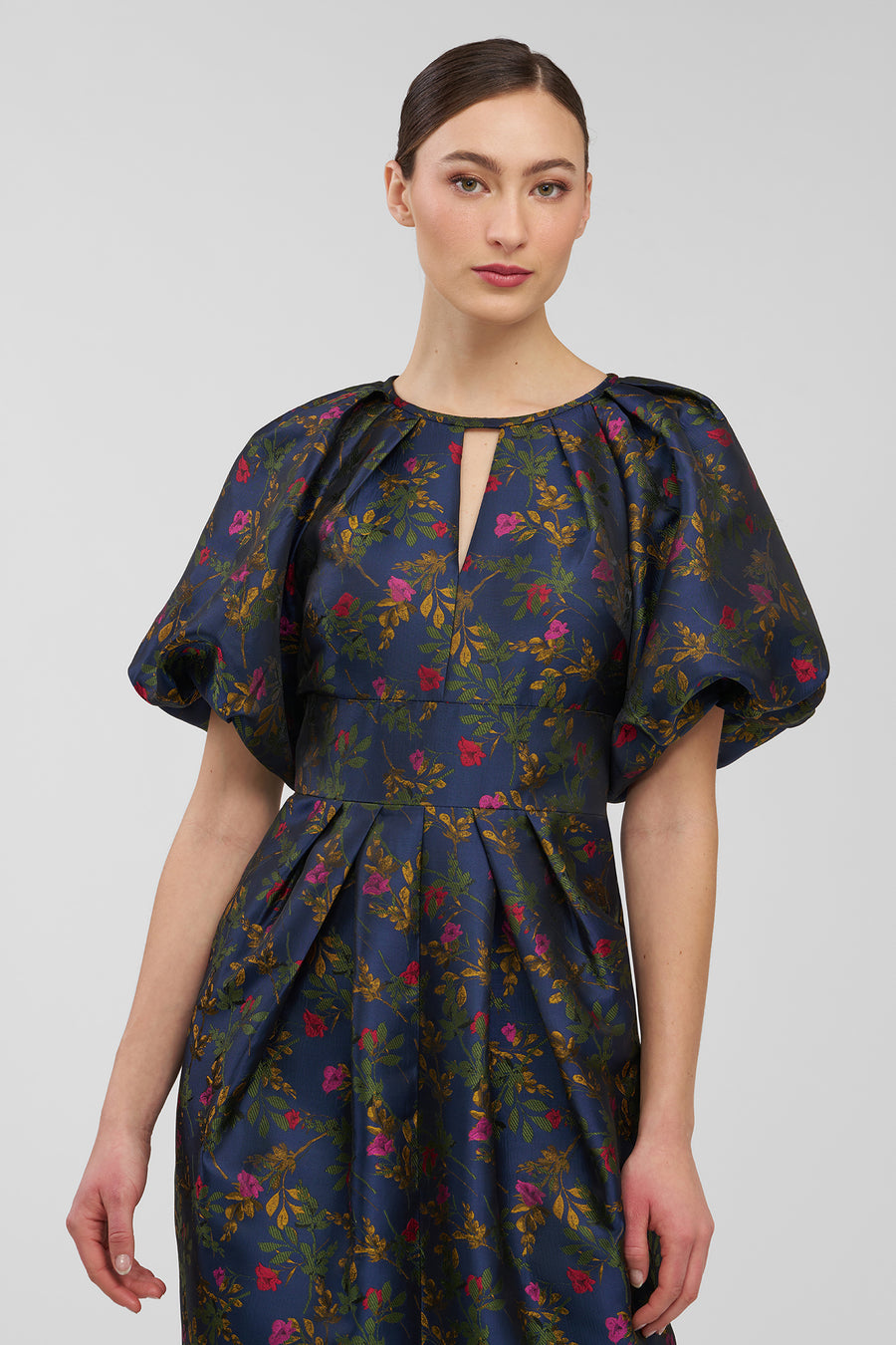 Woman wearing a floral dress with a plain background