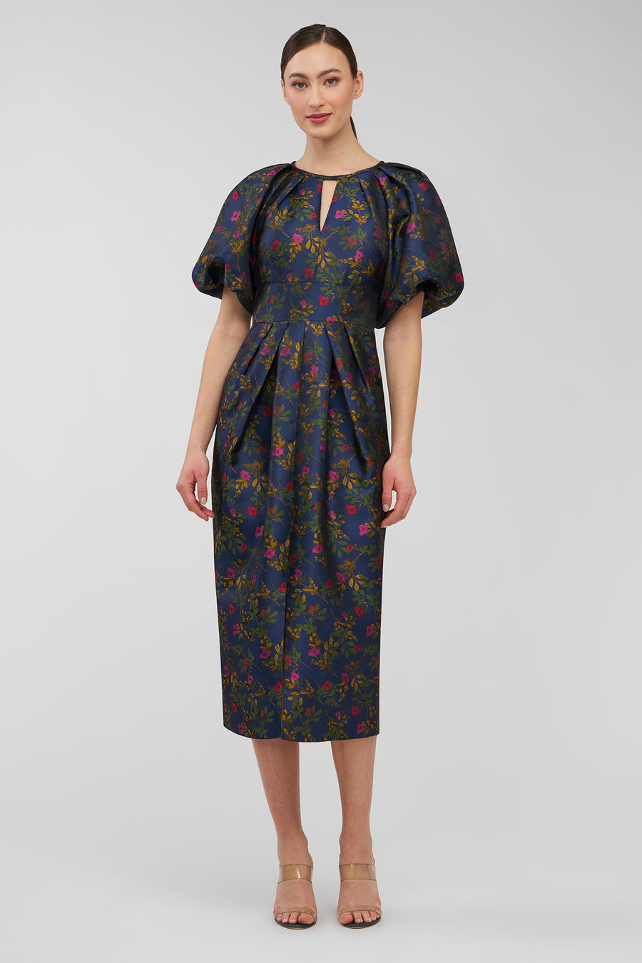 Woman wearing a floral dress on a plain background