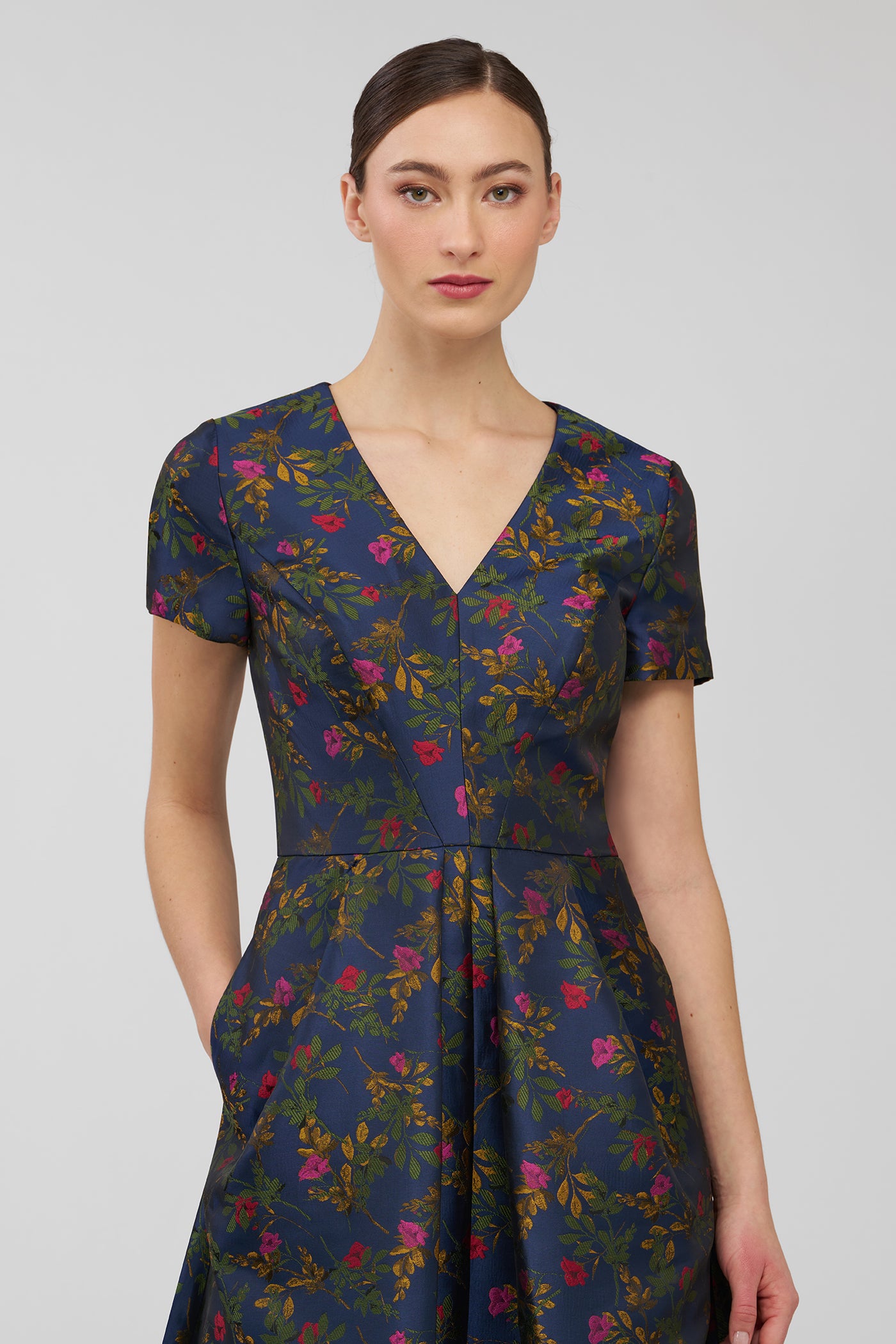 Woman wearing a floral dress on a plain background