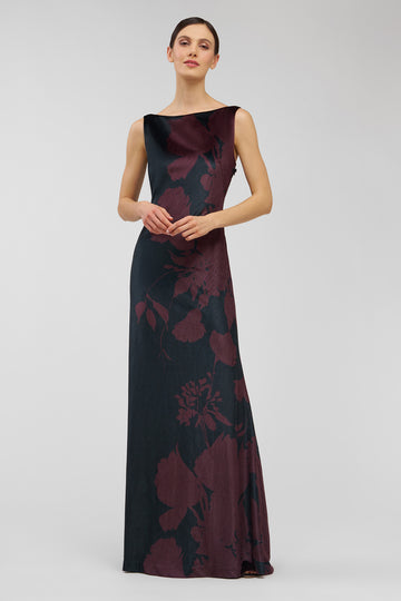 Woman wearing a dark floral patterned dress on a light gray background