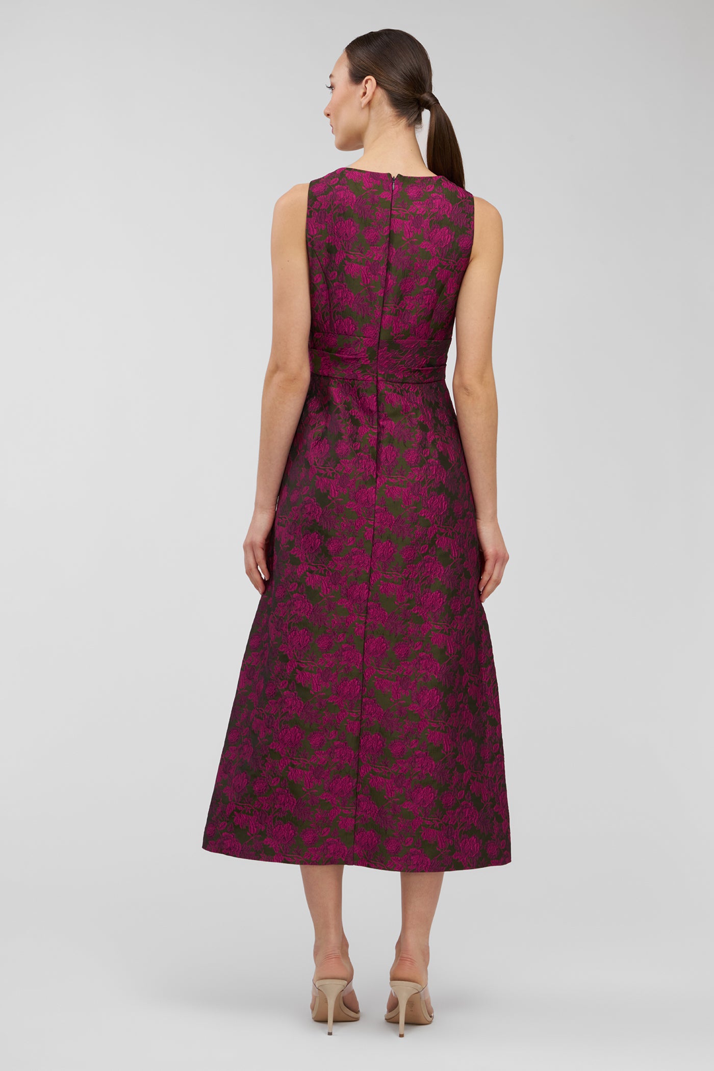 Woman wearing a sleeveless dress with a floral pattern on a white background