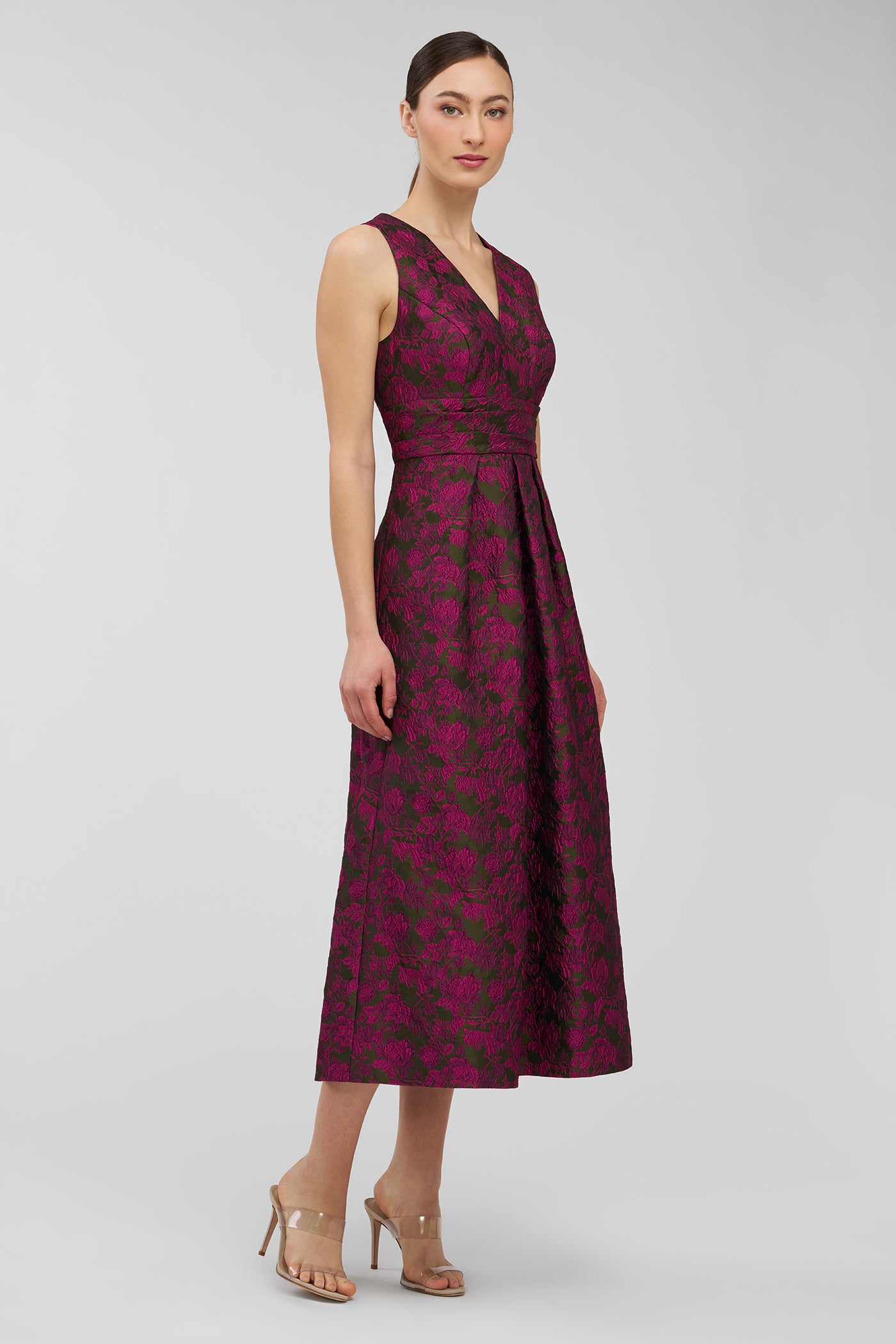 Woman wearing a burgundy floral dress on a light gray background