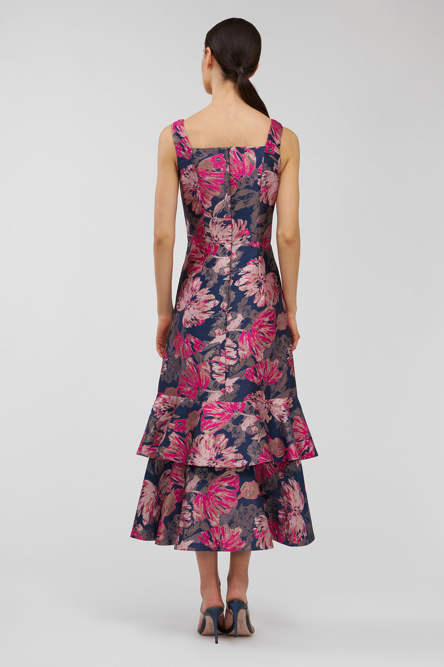 Woman wearing a floral dress on a plain background
