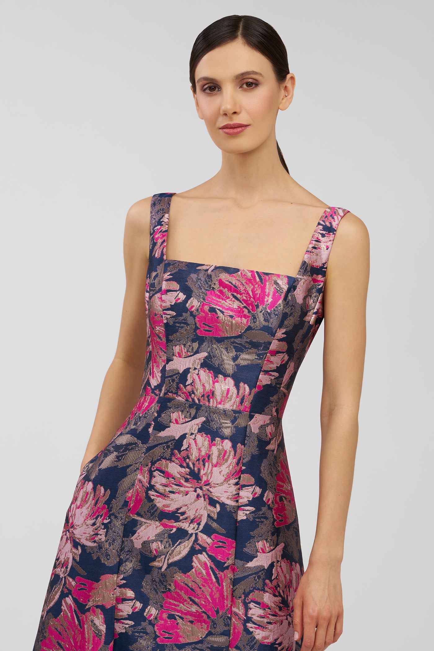 Woman wearing a floral dress on a plain background