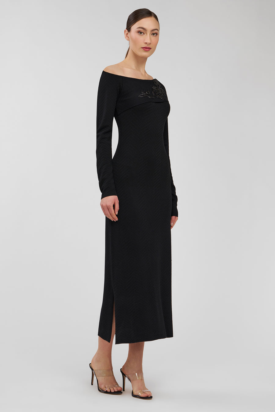 Woman wearing a black off-shoulder dress on a white background