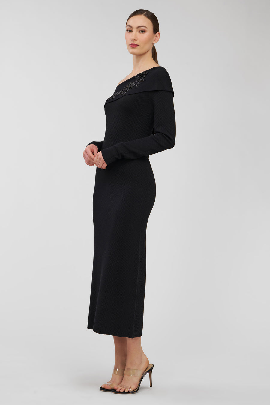 Woman wearing a black off-shoulder dress on a white background