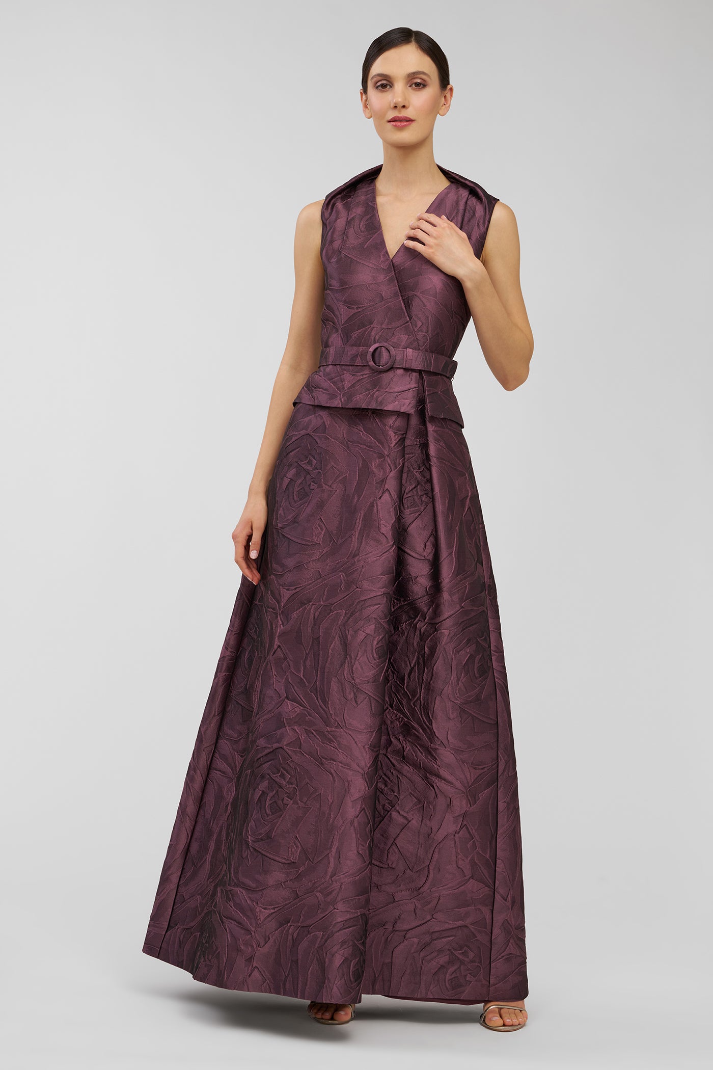 Woman wearing a long, patterned dress on a plain background