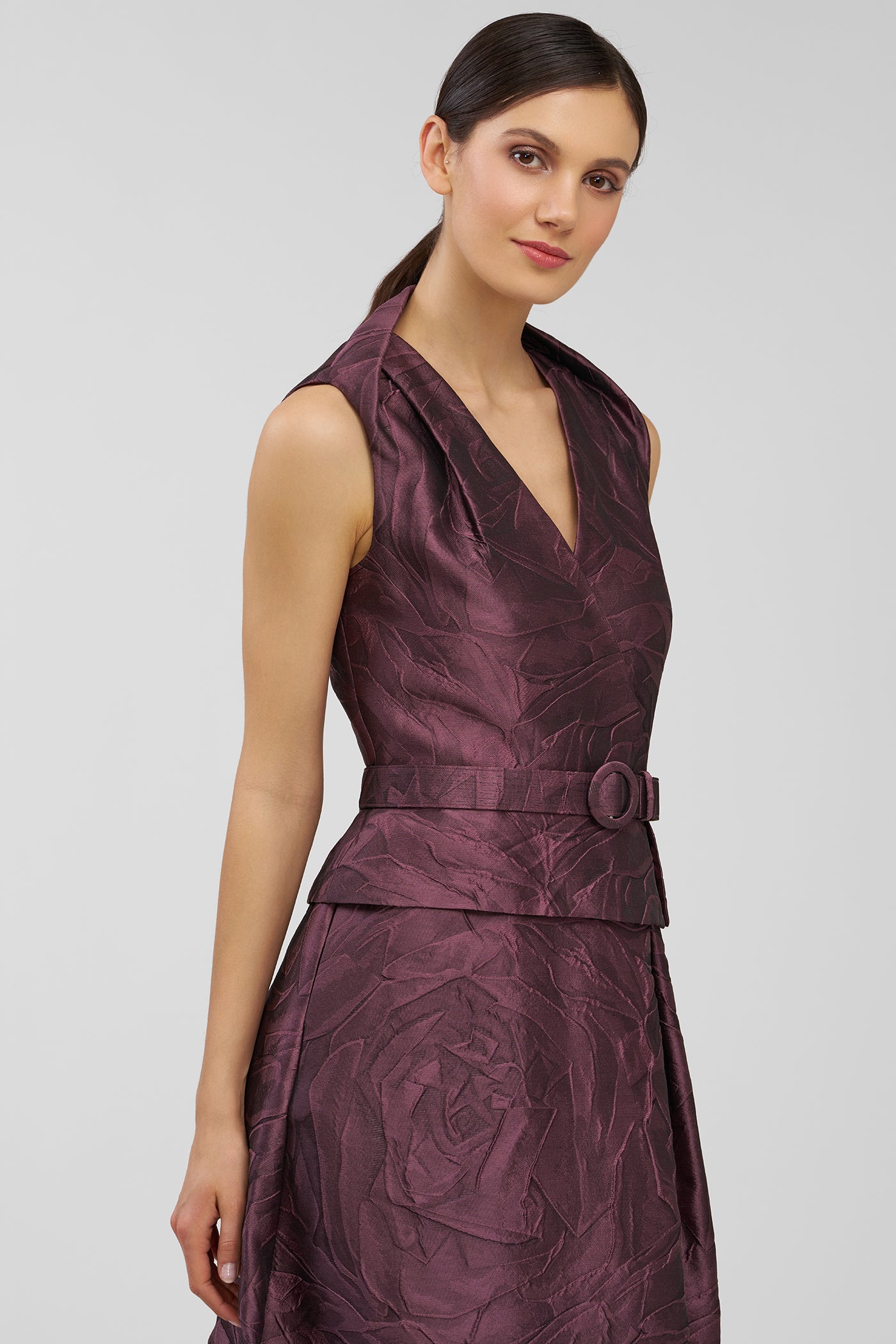 Woman wearing a burgundy patterned dress on a white background