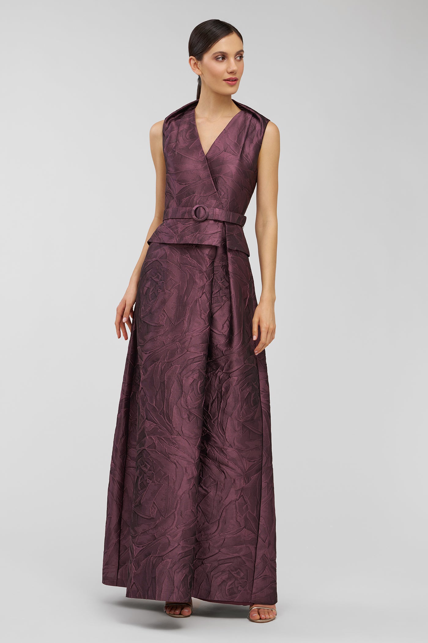 Woman wearing a purple formal gown on a gray background