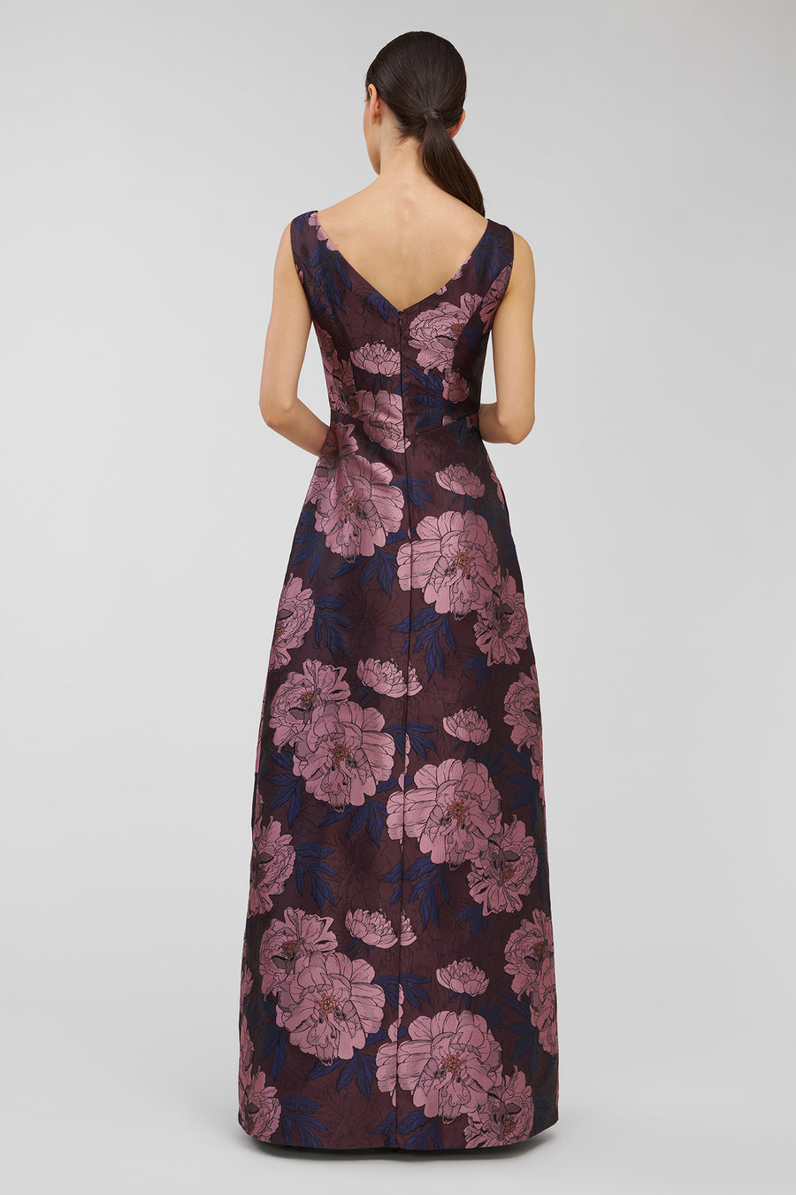 Woman wearing a floral patterned dress on a plain background