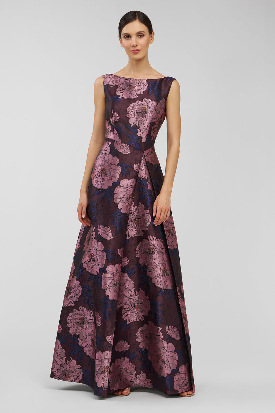 Woman wearing a floral patterned dress on a plain background