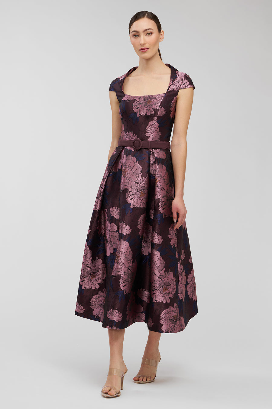 Woman wearing a sleeveless floral dress on a white background