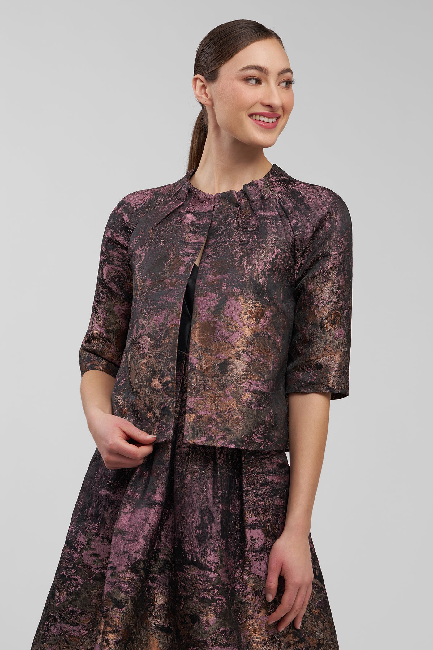 Woman wearing a patterned outfit on a plain background