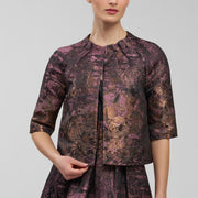 Woman wearing a patterned outfit on a plain background