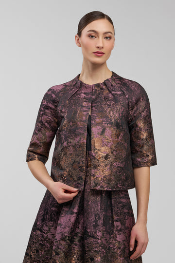 Woman wearing a patterned outfit on a plain background