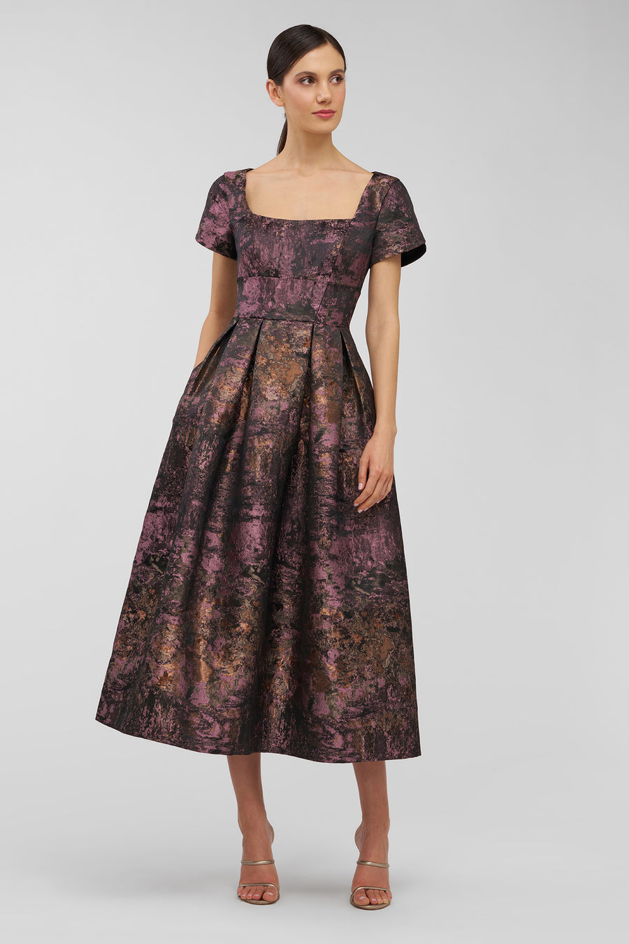 Woman wearing a patterned dress on a plain background