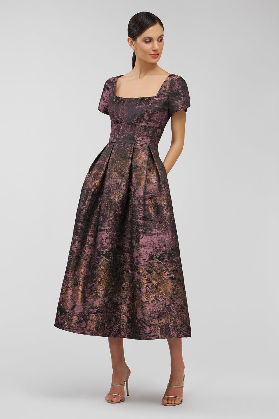 Woman wearing a patterned dress on a plain background