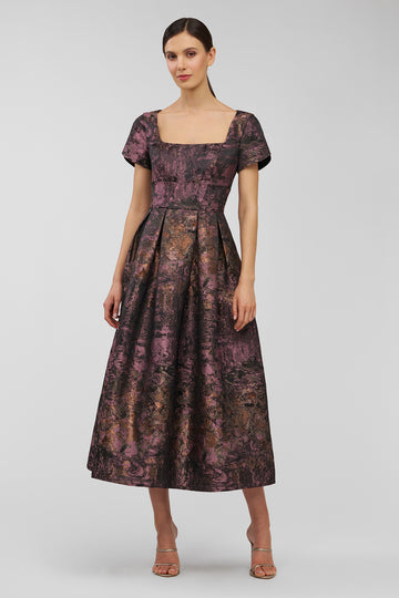 Woman wearing a patterned dress on a white background