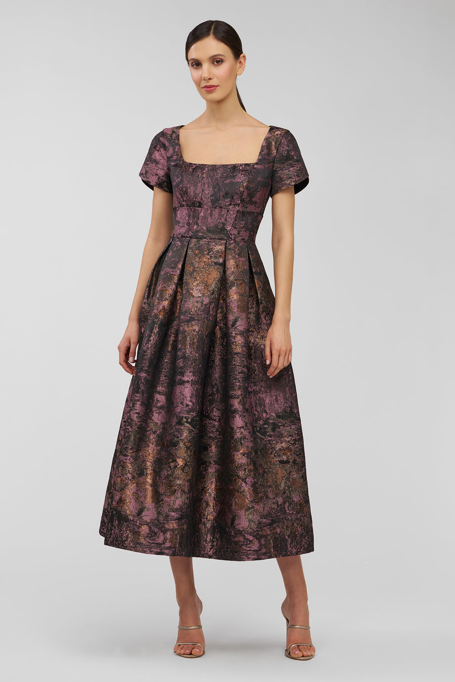 Woman wearing a patterned dress on a white background