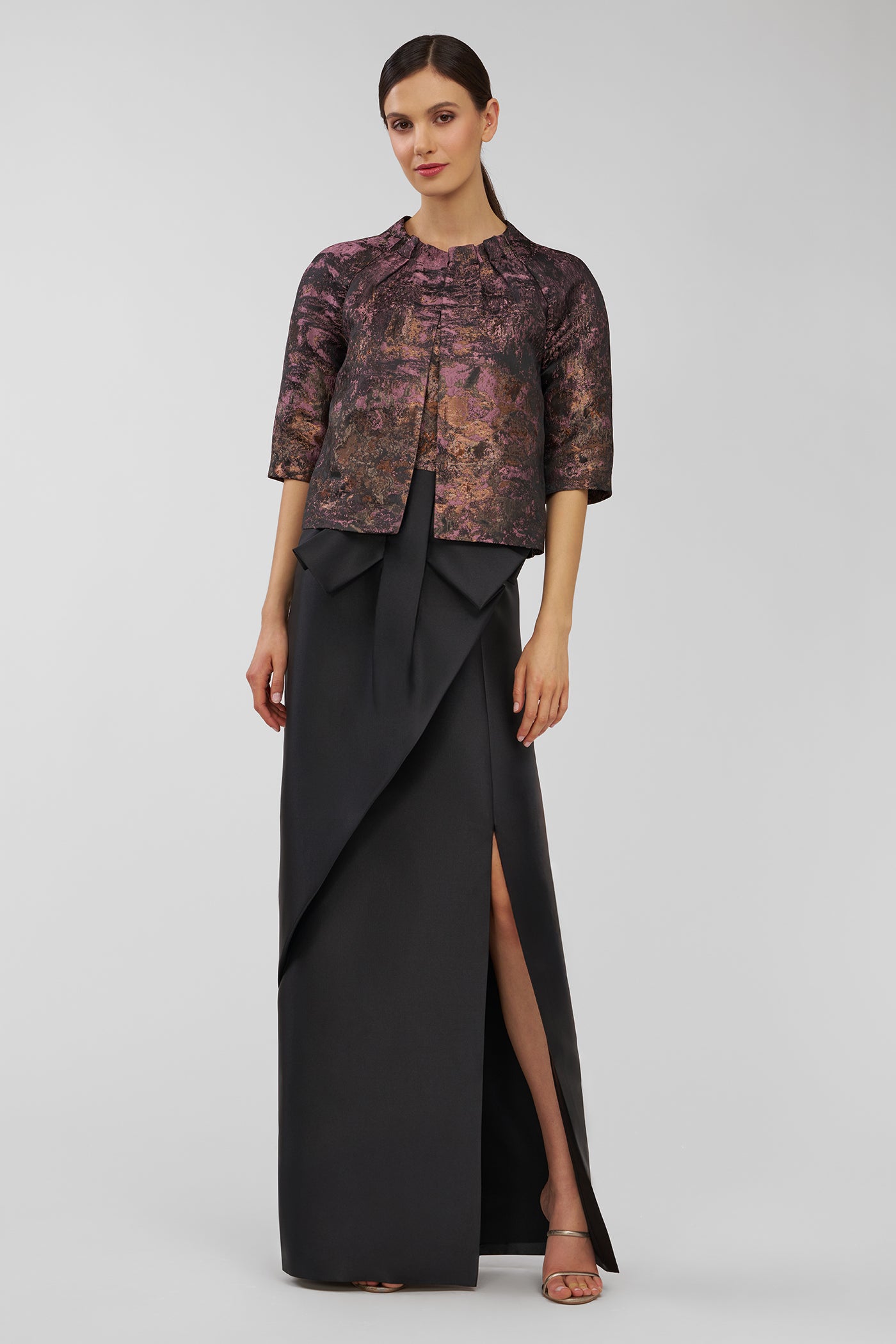 Woman wearing a patterned top and black skirt on a white background