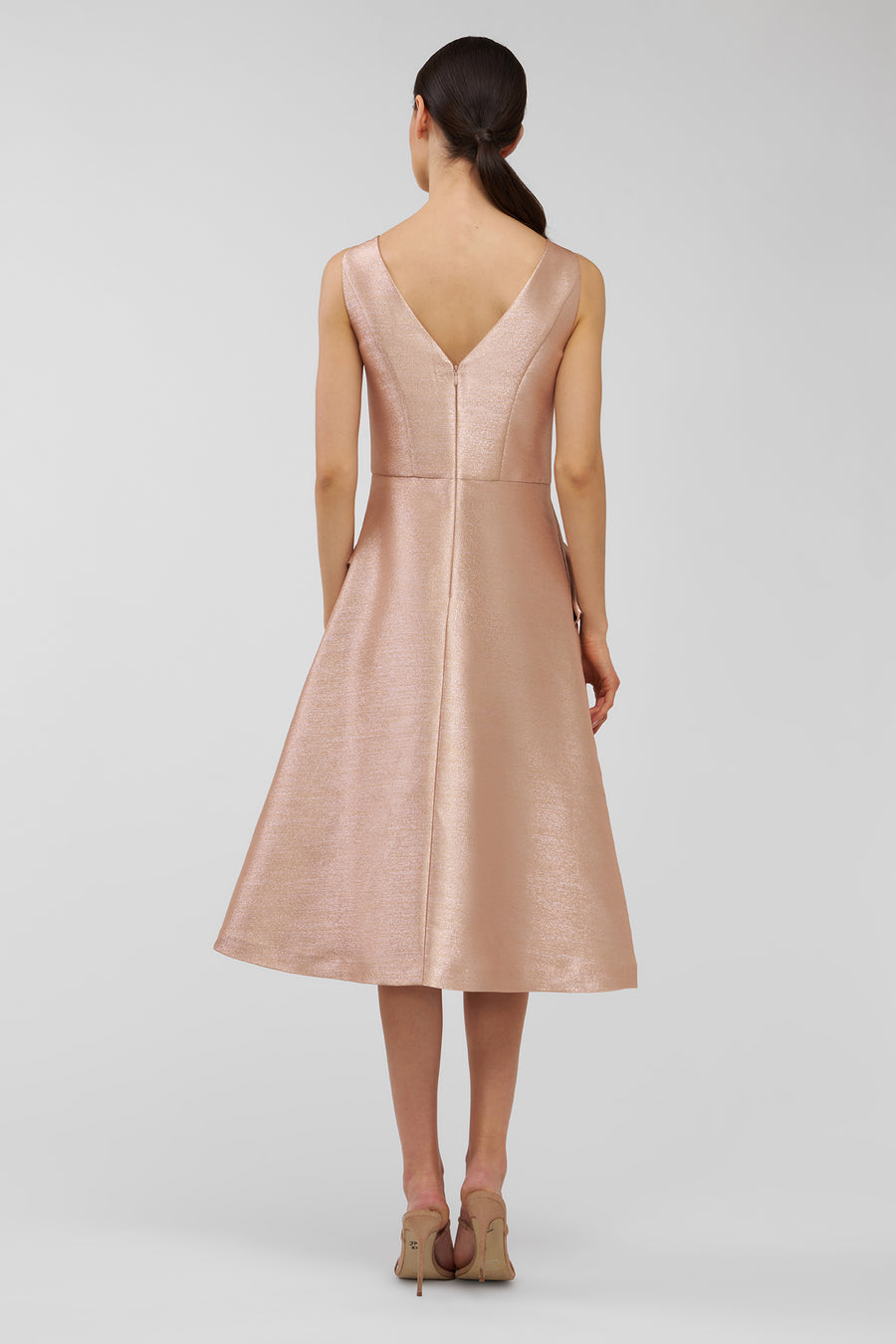 Woman wearing a pink dress with a V-neckline on a white background