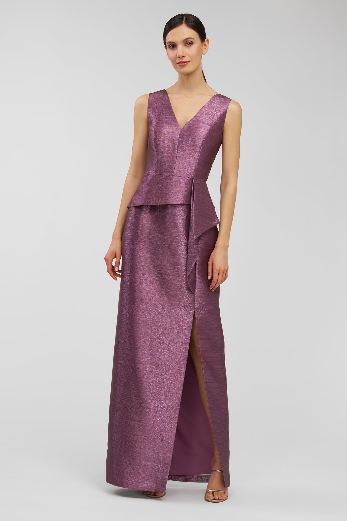 Woman wearing a purple evening gown on a light gray background