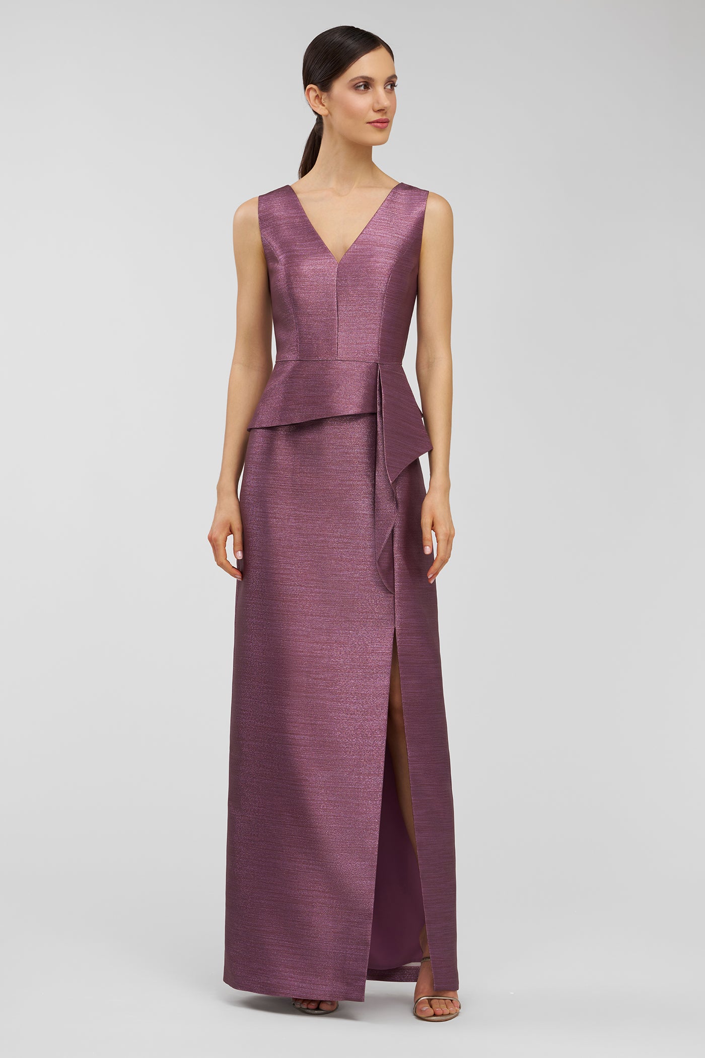 Woman wearing a purple evening gown on a light gray background