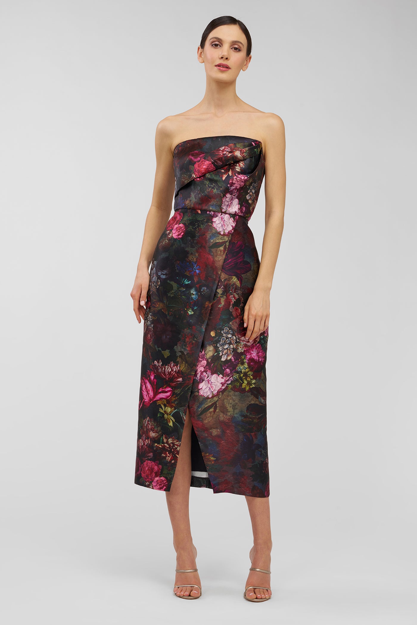 Woman wearing a strapless floral dress on a light gray background