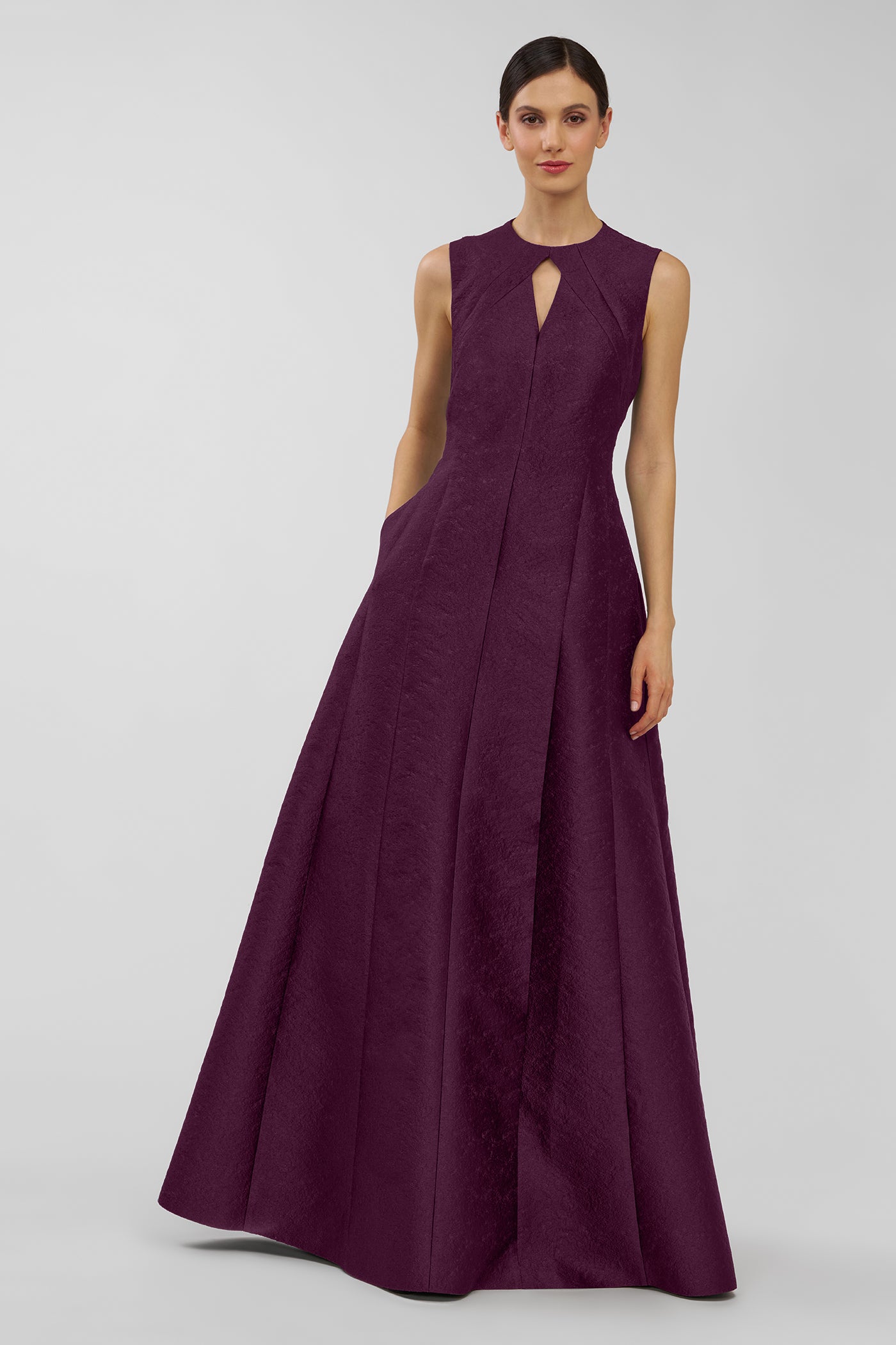 Woman wearing a long purple dress on a white background