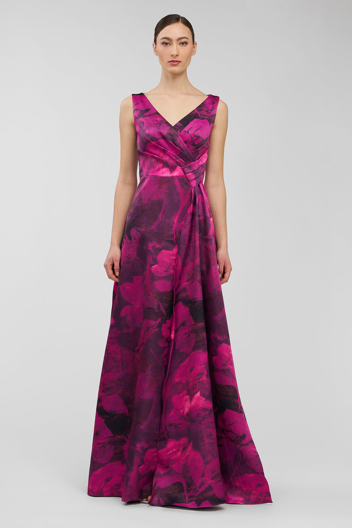 Woman wearing a vibrant pink and purple floral patterned dress on a light gray background